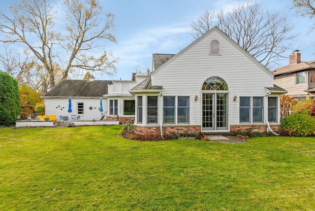 rear view of house with a lawn and a patio area