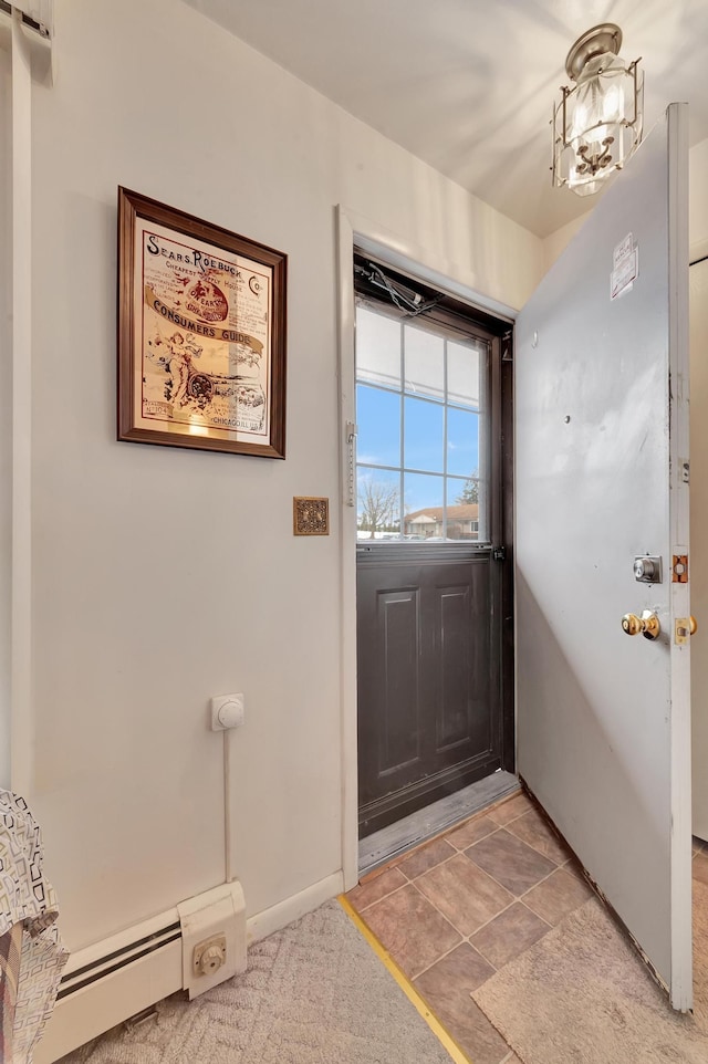 doorway to outside with a notable chandelier and baseboard heating