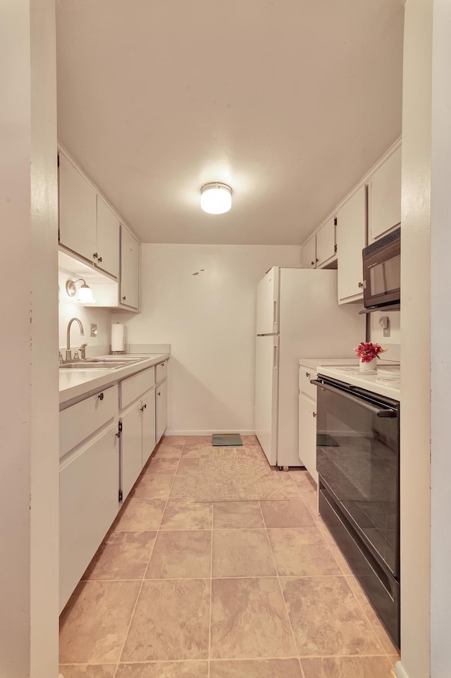 kitchen with stove, sink, white cabinets, and white refrigerator