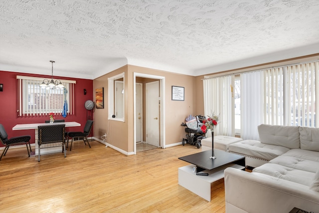 living room featuring hardwood / wood-style flooring, an inviting chandelier, and a textured ceiling