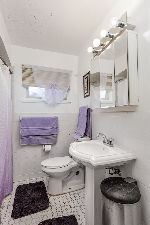 bathroom with tile walls, tile patterned floors, and toilet