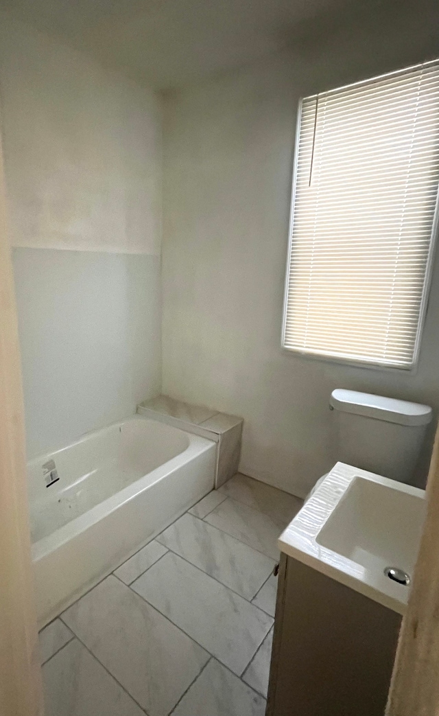 bathroom with vanity, a bathtub, and toilet