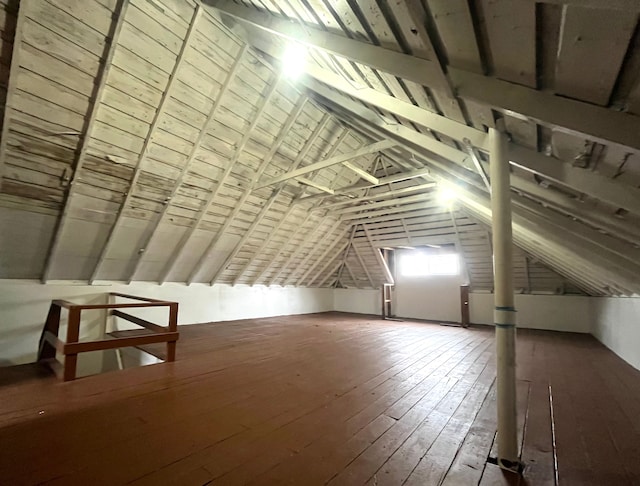 additional living space with hardwood / wood-style flooring and lofted ceiling