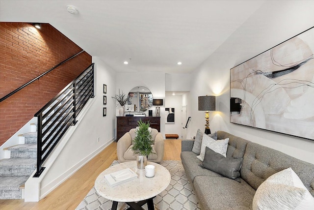 living room with brick wall and light wood-type flooring