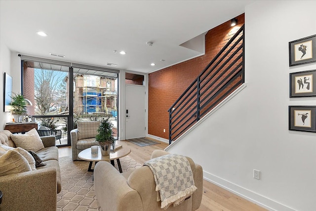 living room with floor to ceiling windows and light hardwood / wood-style flooring