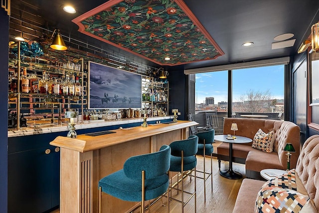 bar with butcher block counters and wood-type flooring