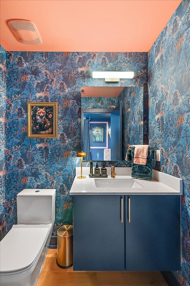 bathroom featuring vanity, hardwood / wood-style flooring, and toilet