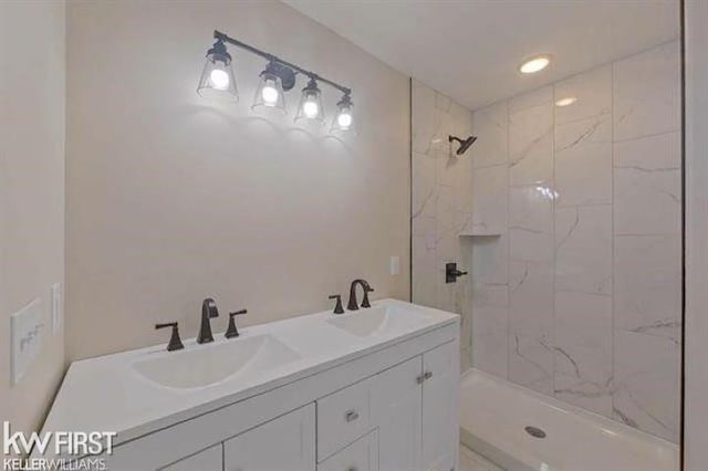 bathroom with vanity and tiled shower