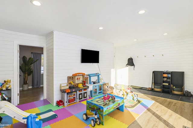 game room with wooden walls and dark hardwood / wood-style floors