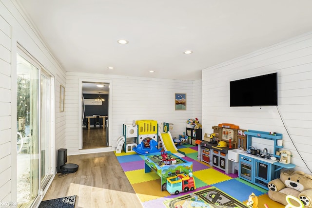 rec room featuring wooden walls and light hardwood / wood-style flooring