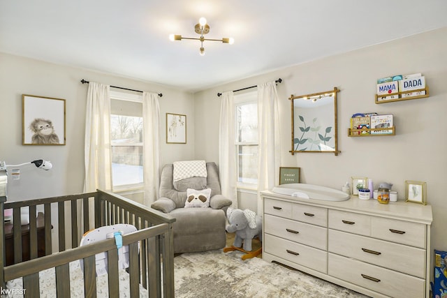 bedroom featuring multiple windows and a nursery area