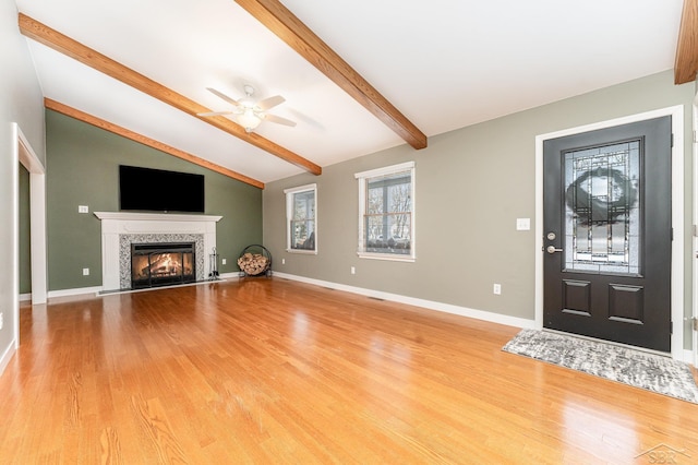 entrance foyer featuring lofted ceiling with beams, a premium fireplace, ceiling fan, and light hardwood / wood-style flooring