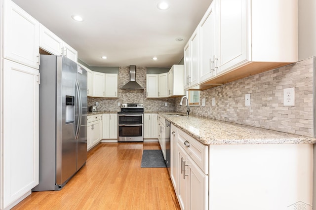 kitchen with white cabinetry, wall chimney range hood, backsplash, and appliances with stainless steel finishes