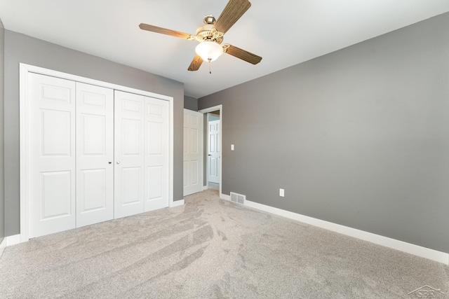 unfurnished bedroom with ceiling fan, carpet, and a closet