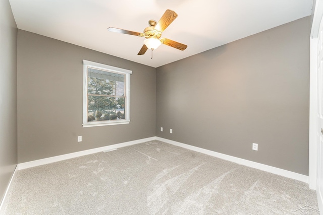 empty room featuring ceiling fan and light carpet