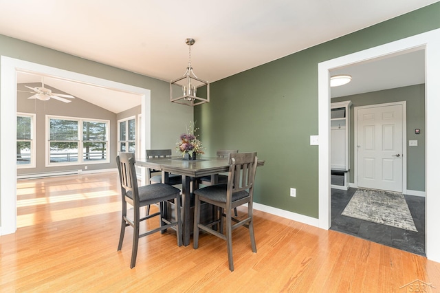 dining area with ceiling fan with notable chandelier, vaulted ceiling, and light hardwood / wood-style floors