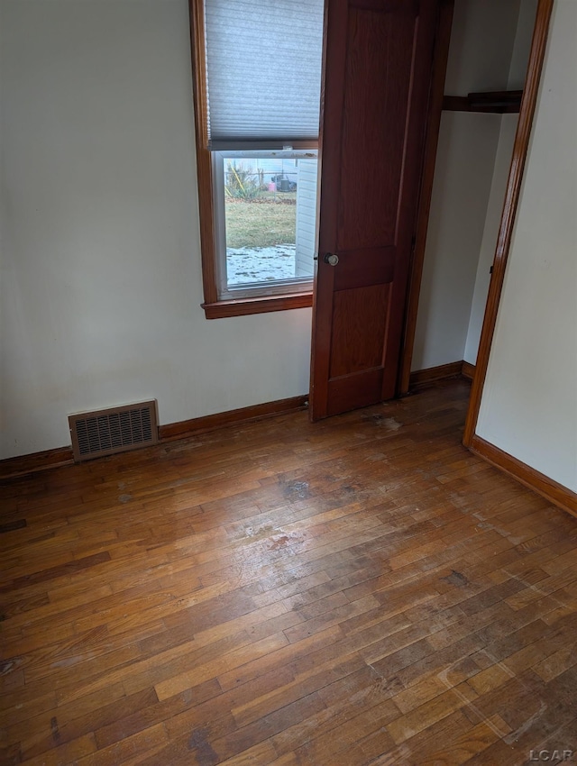 unfurnished bedroom with dark hardwood / wood-style flooring and a closet