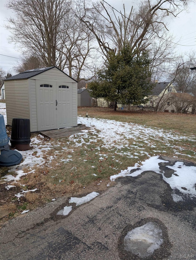 yard covered in snow featuring a storage unit