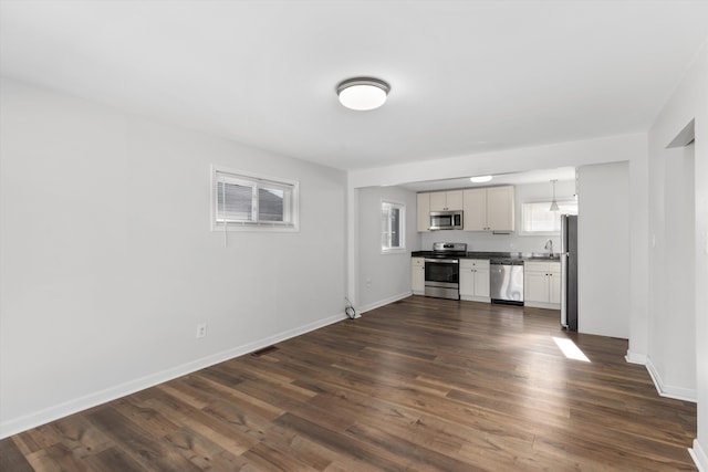 unfurnished living room featuring dark hardwood / wood-style flooring and sink