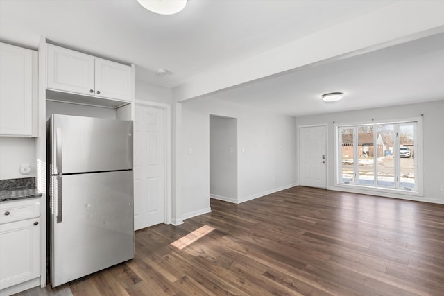 kitchen with dark hardwood / wood-style flooring, stainless steel refrigerator, and white cabinets