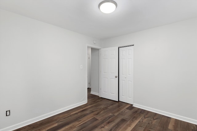 unfurnished bedroom featuring dark wood-type flooring and a closet