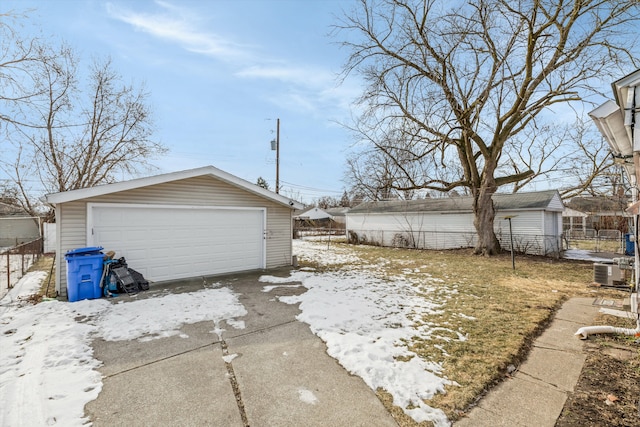 snow covered garage featuring central AC unit