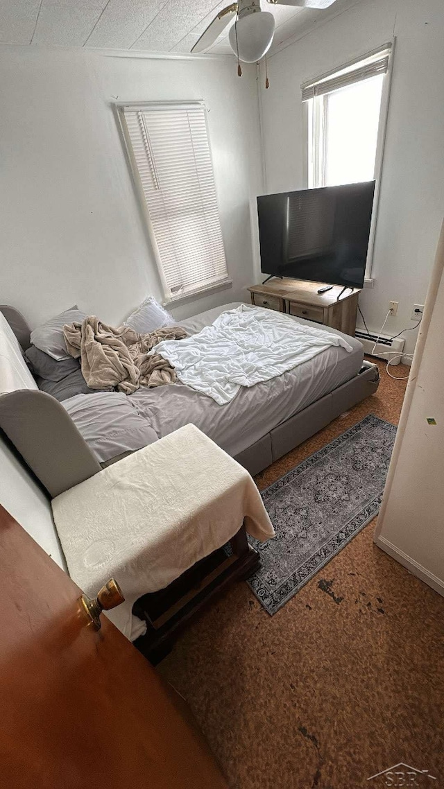 bedroom with a baseboard radiator, a ceiling fan, and carpet