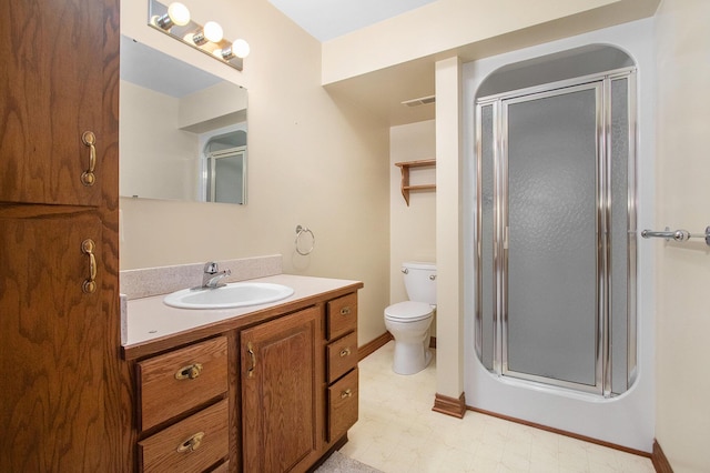 bathroom featuring a shower with door, vanity, and toilet