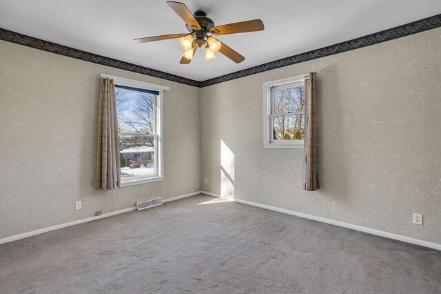 carpeted spare room featuring ceiling fan