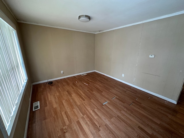 spare room with crown molding, hardwood / wood-style floors, and a wealth of natural light