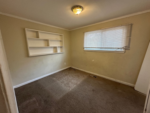 carpeted spare room with built in shelves and crown molding