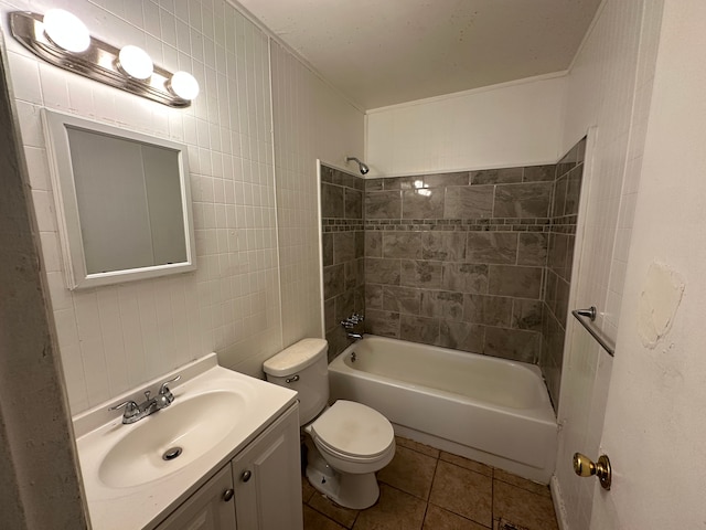 full bathroom with tile patterned floors, toilet, tiled shower / bath, tile walls, and vanity