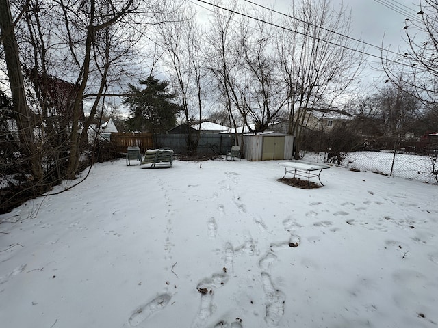 yard layered in snow with a storage unit