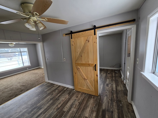 interior space with a barn door and dark carpet