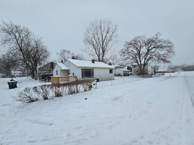 snow covered back of property with a deck