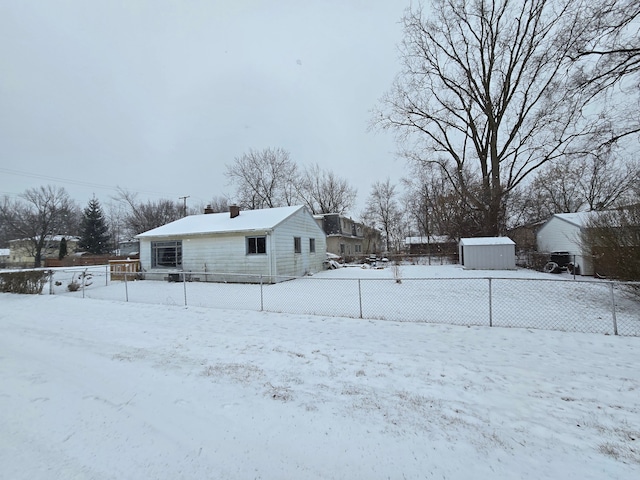 snowy yard featuring a storage shed