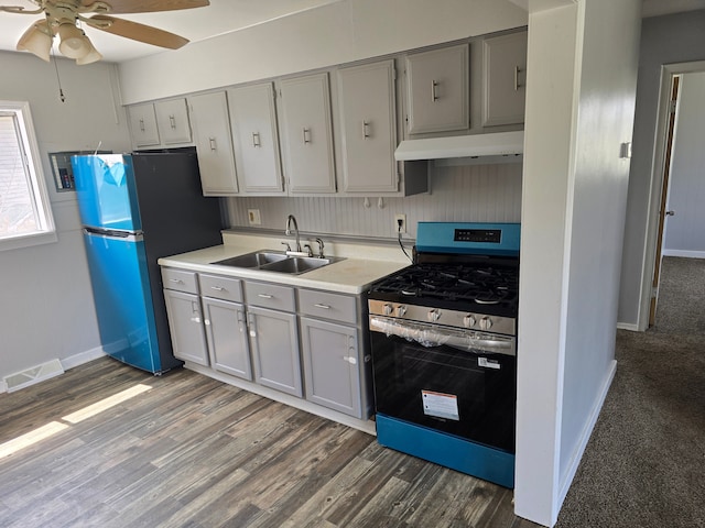 kitchen featuring under cabinet range hood, stainless steel appliances, a ceiling fan, a sink, and gray cabinetry