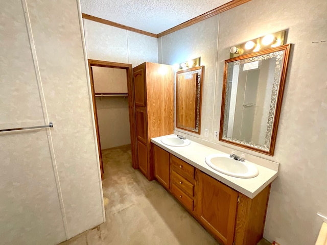 bathroom featuring vanity, ornamental molding, and a textured ceiling