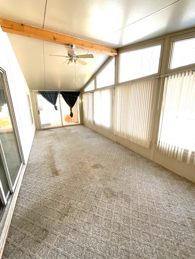 unfurnished sunroom with ceiling fan and vaulted ceiling with beams