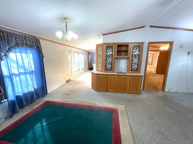 interior space with an inviting chandelier, vaulted ceiling, light carpet, and a textured ceiling