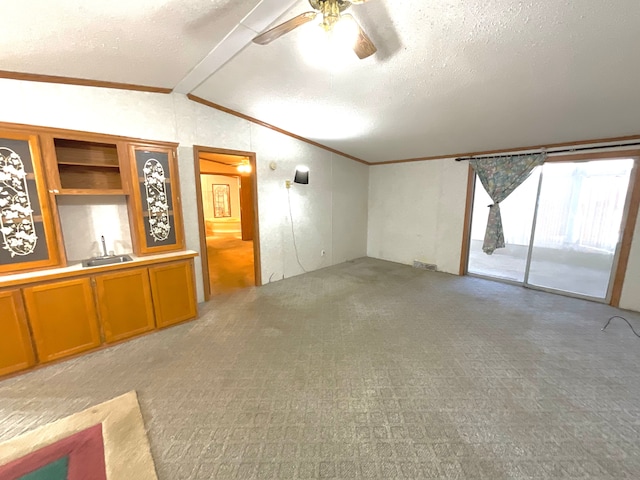 unfurnished living room with vaulted ceiling, ornamental molding, sink, and a textured ceiling