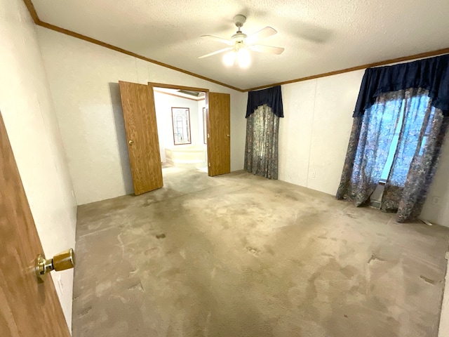 empty room featuring crown molding, ceiling fan, carpet flooring, a textured ceiling, and vaulted ceiling