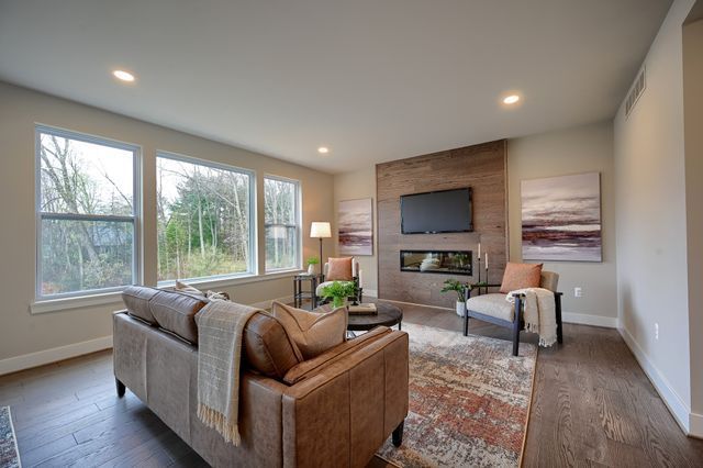 living room with a large fireplace and dark wood-type flooring