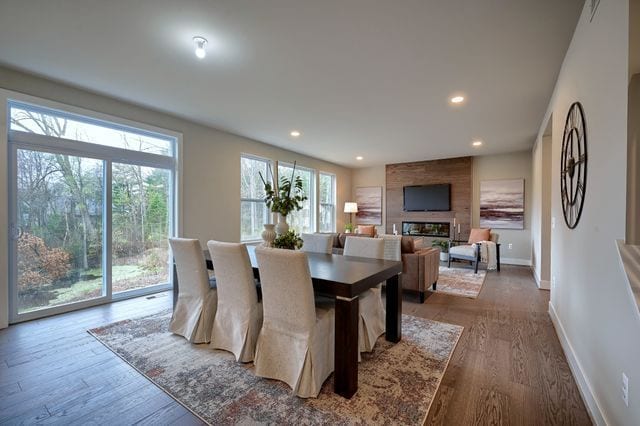 dining room with a large fireplace and wood-type flooring