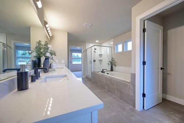 bathroom with shower with separate bathtub, vanity, and tile patterned floors