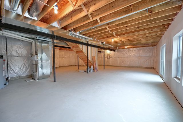 basement with electric water heater and heating unit