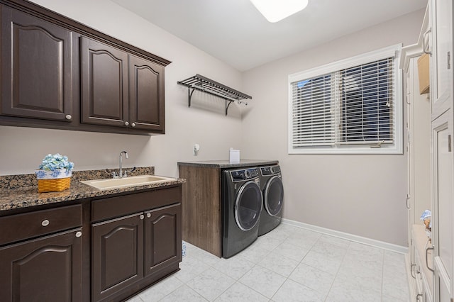 clothes washing area with cabinets, sink, and washing machine and clothes dryer