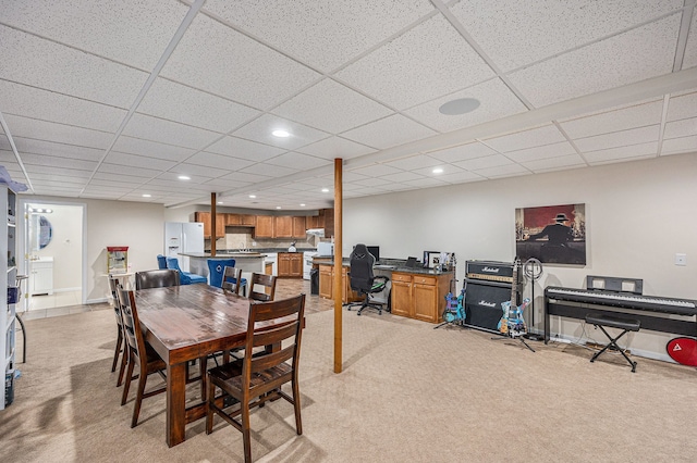 carpeted dining room featuring a drop ceiling