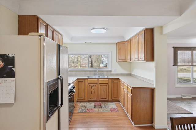 kitchen with plenty of natural light, range, sink, and white fridge with ice dispenser