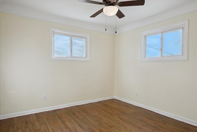 spare room featuring plenty of natural light, dark wood-type flooring, and ceiling fan